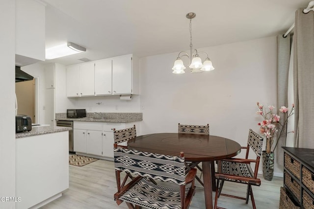 3700 Dean Dr Unit 1805, Ventura, CA 93003 - kitchen featuring light wood-style flooring, white cabinetry, stainless steel dishwasher, a chandelier, and black microwave