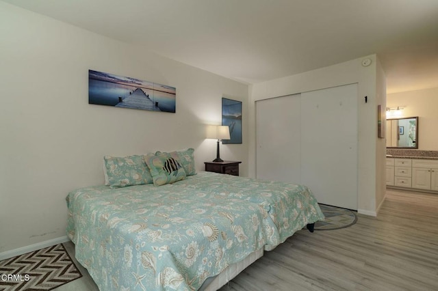 3700 Dean Dr Unit 1805, Ventura, CA 93003 - bedroom featuring a closet, baseboards, light wood-type flooring, and connected bathroom