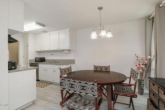 3700 Dean Dr Unit 1805, Ventura, CA 93003 - kitchen featuring light wood finished floors, white cabinets, dishwasher, a chandelier, and black microwave