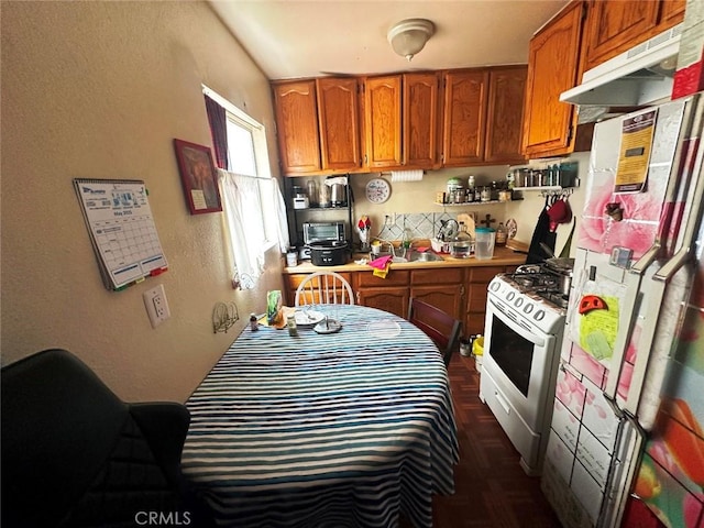1136 Arapahoe St, Los Angeles, CA 90006 - kitchen featuring white appliances, under cabinet range hood, a textured wall, brown cabinetry, and light countertops