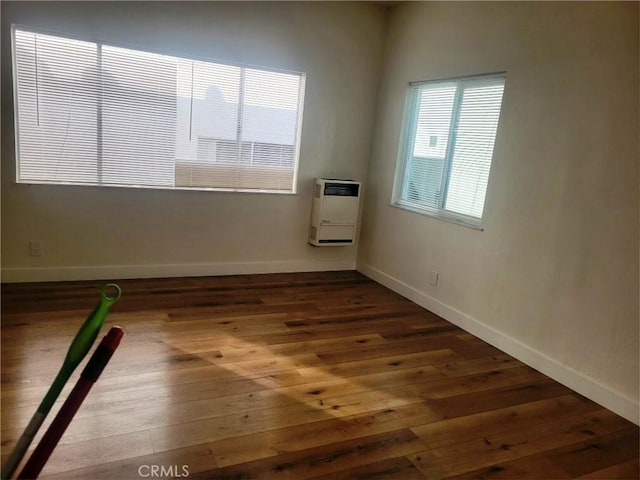 1136 Arapahoe St, Los Angeles, CA 90006 - empty room featuring heating unit, dark wood-style floors, and baseboards