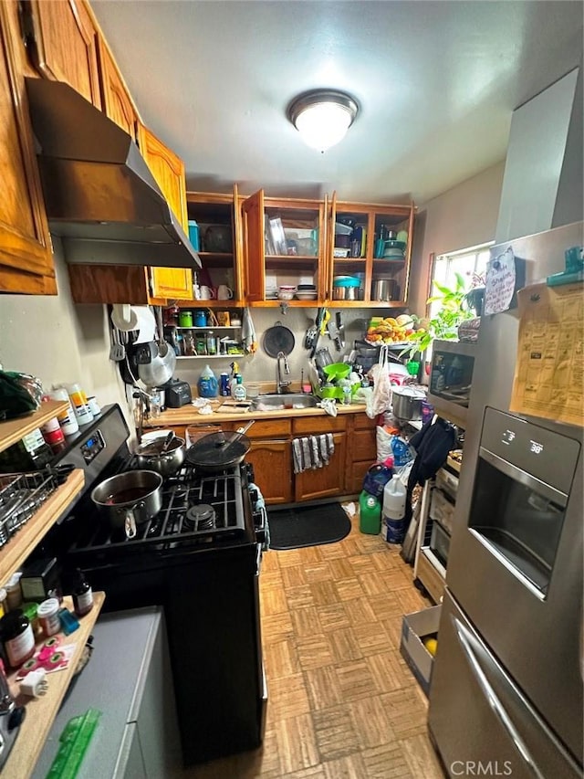 1136 Arapahoe St, Los Angeles, CA 90006 - kitchen featuring stainless steel fridge, under cabinet range hood, black gas stove, a sink, and brown cabinets