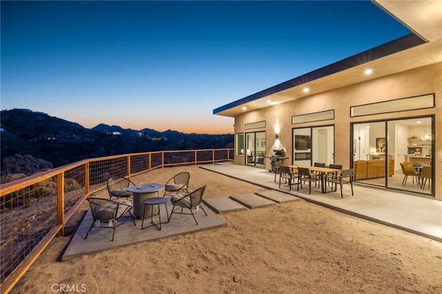 5890 Olema Rd, Yucca Valley, CA 92284 - patio terrace at dusk featuring a fire pit, a mountain view, and a patio
