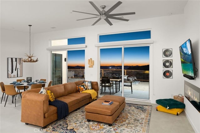 5890 Olema Rd, Yucca Valley, CA 92284 - living room featuring a chandelier, ceiling fan, and finished concrete flooring