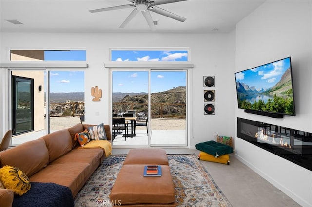 5890 Olema Rd, Yucca Valley, CA 92284 - living area with a ceiling fan, healthy amount of natural light, baseboards, and a glass covered fireplace
