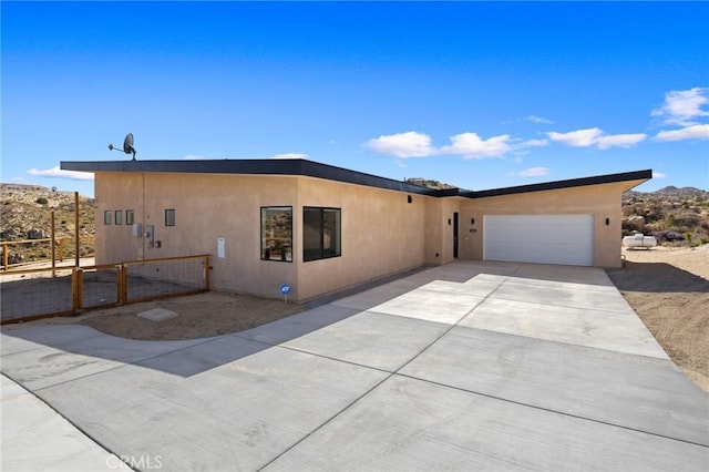 5890 Olema Rd, Yucca Valley, CA 92284 - view of front of property with a garage, stucco siding, and driveway