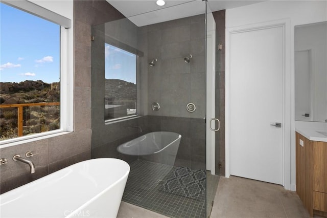 5890 Olema Rd, Yucca Valley, CA 92284 - bathroom featuring a shower stall, vanity, a soaking tub, healthy amount of natural light, and tile walls