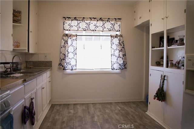 73752 Crestview Dr Unit 29, Palms, CA 92277 - kitchen with a sink, white cabinets, wood finished floors, dark countertops, and baseboards