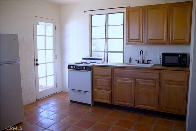 73752 Crestview Dr Unit 29, Palms, CA 92277 - kitchen with a sink, white electric range, black microwave, and freestanding refrigerator