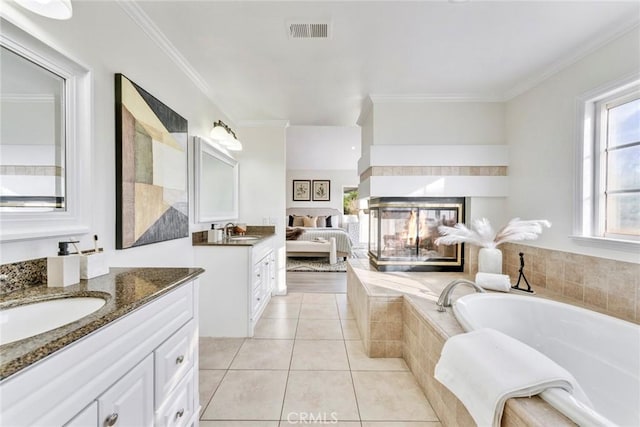 2563 Pepperdale Dr, Rowland Heights, CA 91748 - bathroom featuring two vanities, a bath, crown molding, tile patterned flooring, and a tiled fireplace