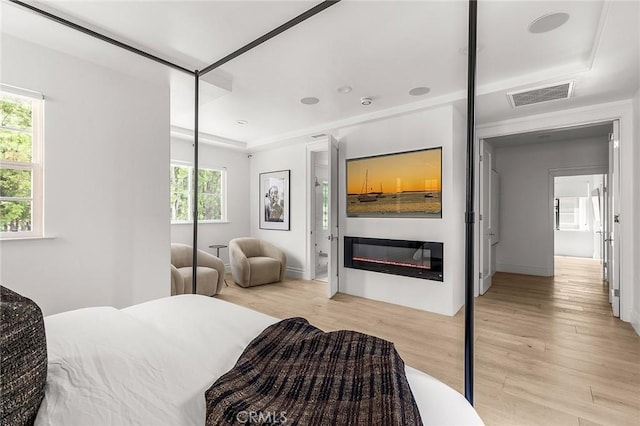 5 Modesto, Irvine, CA 92602 - bedroom with light wood-style flooring and a glass covered fireplace
