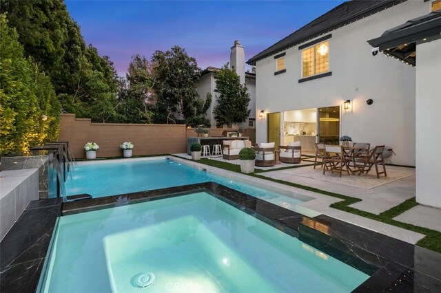 5 Modesto, Irvine, CA 92602 - pool at dusk with an in-ground hot tub, a patio area, outdoor lounge area, and outdoor dining space