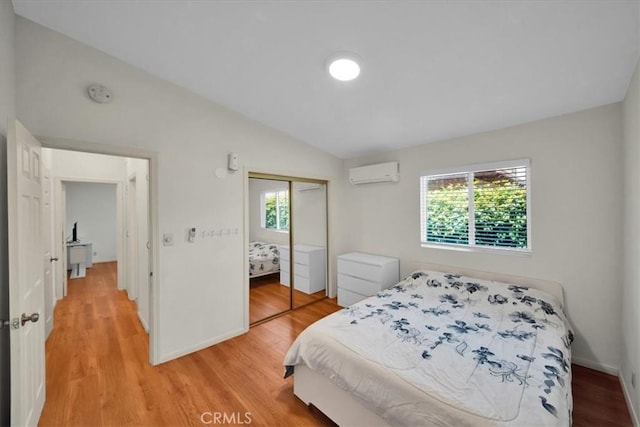 15510 Midcrest Dr, Whittier, CA 90604 - bedroom featuring a wall unit AC, a closet, light wood-style flooring, vaulted ceiling, and baseboards