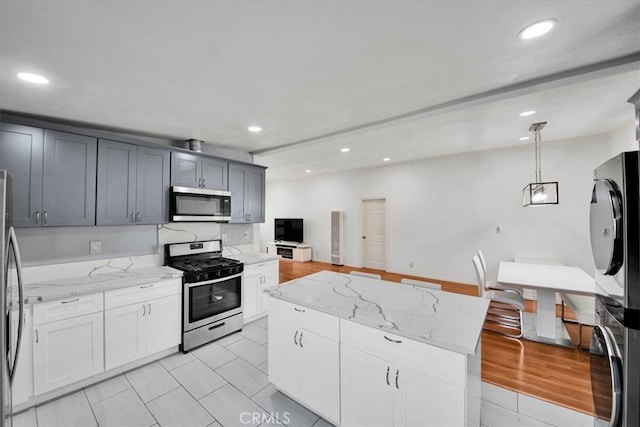 15510 Midcrest Dr, Whittier, CA 90604 - kitchen with stainless steel appliances, recessed lighting, hanging light fixtures, light stone counters, and light tile patterned floors