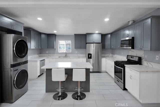 15510 Midcrest Dr, Whittier, CA 90604 - kitchen with appliances with stainless steel finishes, stacked washer / dryer, a sink, a center island, and light stone countertops