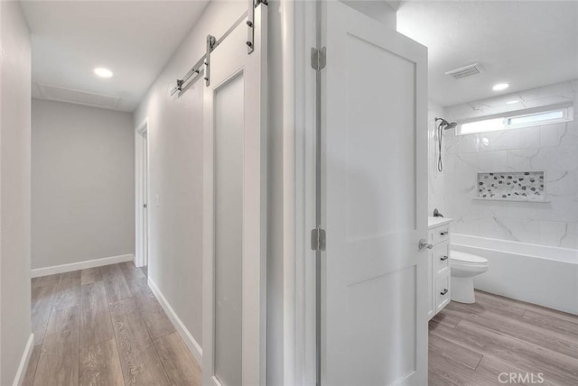 7747 Onyx Ave, Rancho Cucamonga, CA 91730 - hallway with light wood-type flooring, recessed lighting, and a barn door