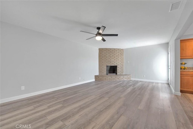 7747 Onyx Ave, Rancho Cucamonga, CA 91730 - unfurnished living room with ceiling fan, light wood-style flooring, baseboards, and a brick fireplace