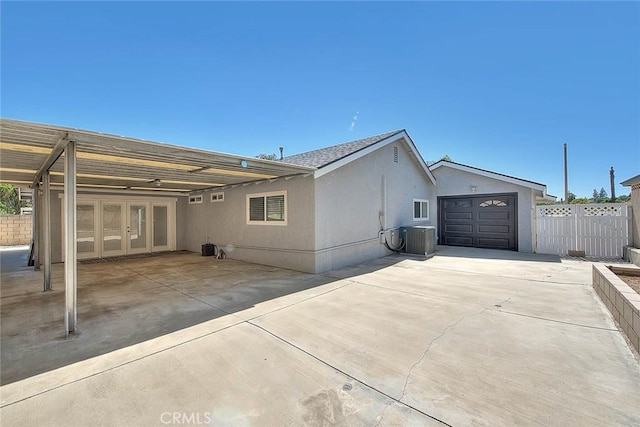 7747 Onyx Ave, Rancho Cucamonga, CA 91730 - rear view of house with central AC, french doors, driveway, a garage, and stucco siding