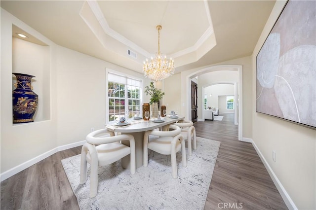 2122 Meteora Way, Rowland Heights, CA 91748 - dining area with a chandelier, arched walkways, wood finished floors, a tray ceiling, and ornamental molding