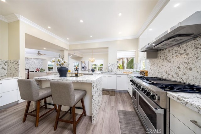 2122 Meteora Way, Rowland Heights, CA 91748 - kitchen with double oven range, a kitchen island, a sink, light wood-style floors, and wall chimney exhaust hood