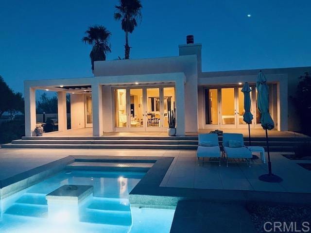 2207 Hoberg Rd, Borrego Springs, CA 92004 - back of house at twilight with a jacuzzi, a patio area, and an outdoor pool