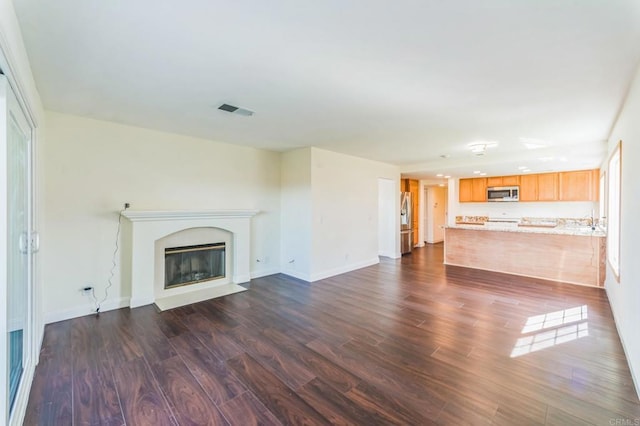 39787 Castile Ave, Murrieta, CA 92562 - unfurnished living room featuring dark wood-style flooring and a fireplace with flush hearth