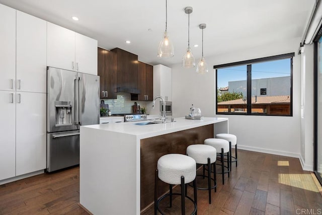 731 Valley Ave, Solana Beach, CA 92075 - kitchen with stainless steel appliances, dark wood-style floors, light countertops, tasteful backsplash, and a breakfast bar