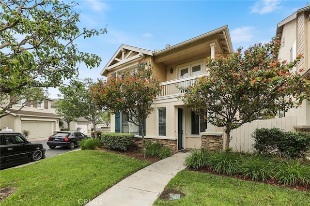 1263 Date Palm Dr, Carson, CA 90746 - view of front of home featuring stone siding, a balcony, a front lawn, and stucco siding