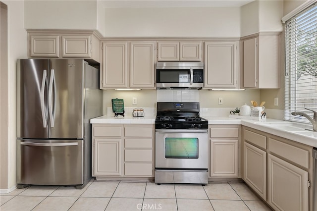 1263 Date Palm Dr, Carson, CA 90746 - kitchen with stainless steel appliances, tile counters, and cream cabinetry