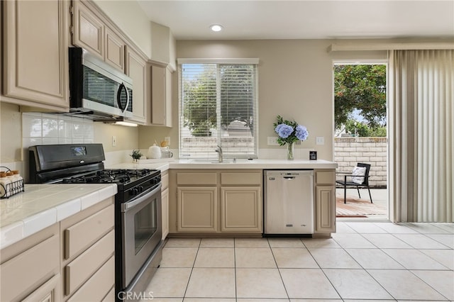 1263 Date Palm Dr, Carson, CA 90746 - kitchen with appliances with stainless steel finishes, a sink, tile counters, plenty of natural light, and recessed lighting