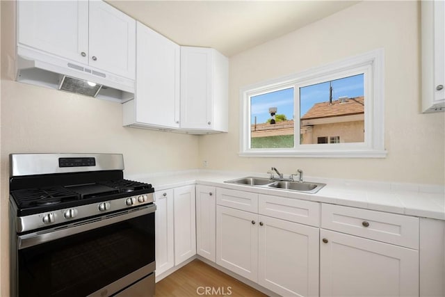 451 N Indiana St, Los Angeles, CA 90063 - kitchen featuring gas stove, a sink, under cabinet range hood, white cabinets, and light countertops