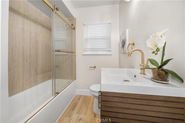 5882 Bowcroft St Unit 2, Los Angeles, CA 90016 - bathroom featuring wood finished floors, vanity, baseboards, toilet, and bath / shower combo with glass door
