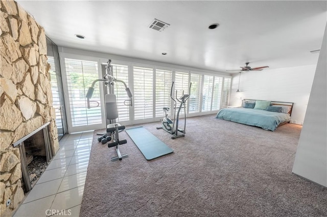 2110 Hathaway Pl, Riverside, CA 92506 - exercise room with tile patterned floors, a stone fireplace, a ceiling fan, and carpet floors