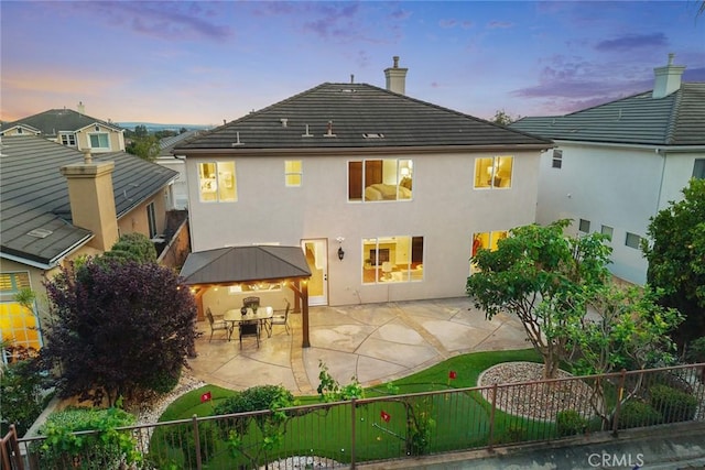 3612 Skylark Way, Brea, CA 92823 - back of property at dusk featuring a patio area, stucco siding, a gazebo, and a chimney