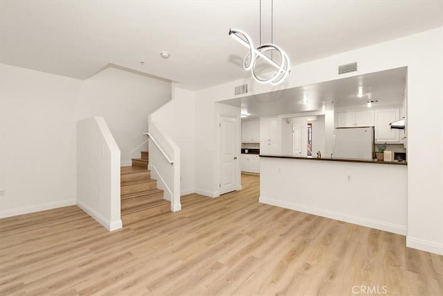 89 E Commonwealth Ave Unit 1I, Alhambra, CA 91801 - kitchen with freestanding refrigerator, dark countertops, white cabinets, and light wood-type flooring