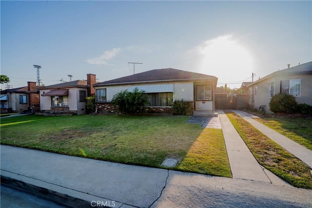 317 N 19th St, Montebello, CA 90640 - view of front of home featuring a front lawn, stucco siding, driveway, and a chimney