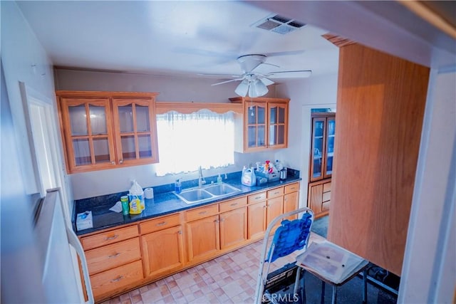 317 N 19th St, Montebello, CA 90640 - kitchen with a sink, ceiling fan, dark countertops, glass insert cabinets, and light floors