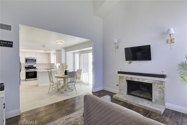 13365 Cloudburst Dr, Corona, CA 92883 - living area with light wood-style flooring and a fireplace with raised hearth