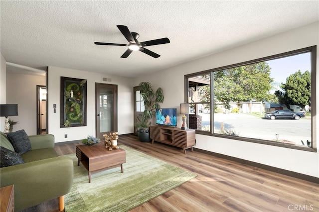 1409 N Midsite Ave, Covina, CA 91722 - living area with a ceiling fan, a textured ceiling, wood finished floors, and baseboards