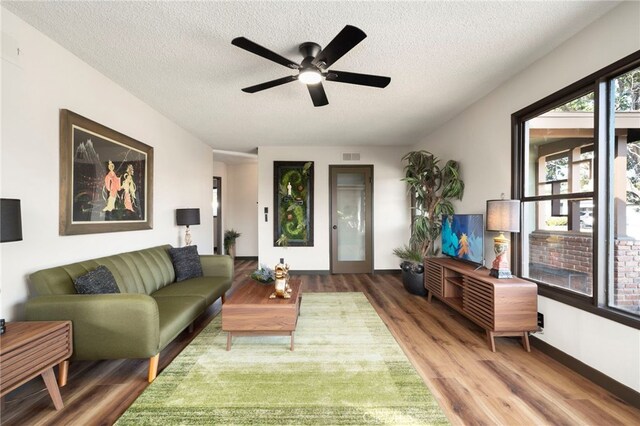 1409 N Midsite Ave, Covina, CA 91722 - living area featuring wood finished floors, a ceiling fan, a textured ceiling, and baseboards