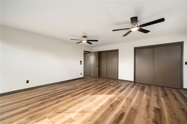 1409 N Midsite Ave, Covina, CA 91722 - unfurnished bedroom featuring two closets, baseboards, light wood finished floors, and a ceiling fan