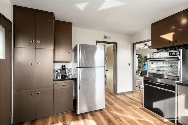 1409 N Midsite Ave, Covina, CA 91722 - kitchen featuring freestanding refrigerator, light wood-style floors, dark countertops, dark brown cabinetry, and baseboards