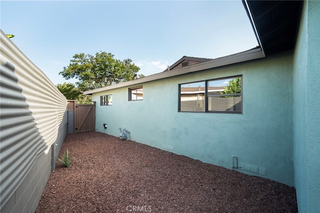 1409 N Midsite Ave, Covina, CA 91722 - view of side of home featuring a gate and stucco siding