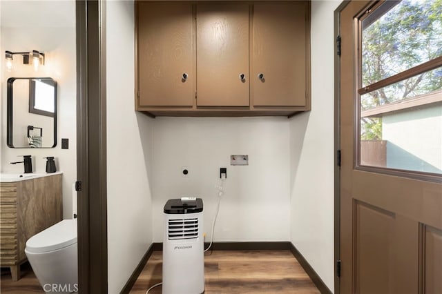 1409 N Midsite Ave, Covina, CA 91722 - laundry room with cabinet space, washer hookup, dark wood-style flooring, and plenty of natural light