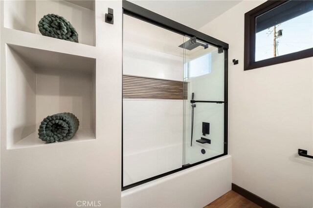 1409 N Midsite Ave, Covina, CA 91722 - bathroom with enclosed tub / shower combo, wood finished floors, and baseboards