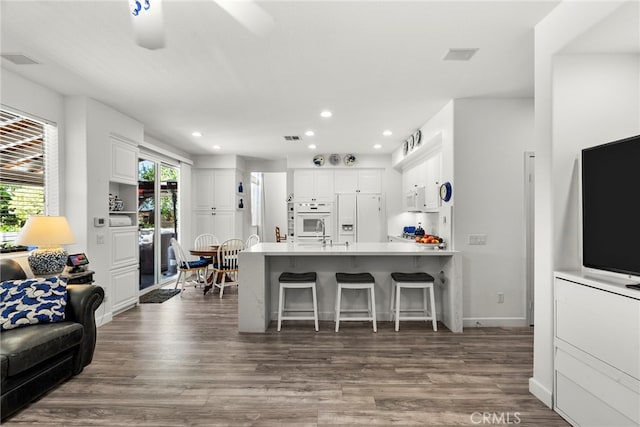 28809 Garnet Canyon Dr, Saugus, CA 91390 - kitchen featuring white appliances, a peninsula, white cabinetry, dark wood-style flooring, and recessed lighting