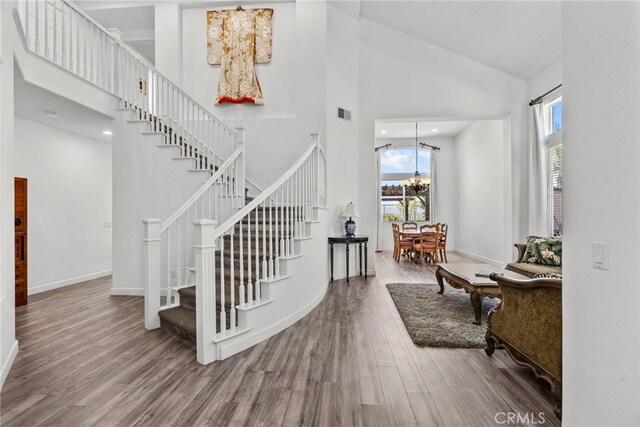 28809 Garnet Canyon Dr, Saugus, CA 91390 - staircase with a chandelier, high vaulted ceiling, plenty of natural light, wood finished floors, and baseboards