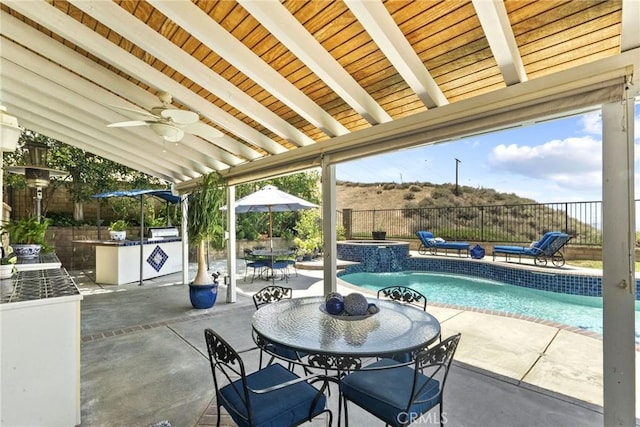 28809 Garnet Canyon Dr, Saugus, CA 91390 - fenced backyard featuring outdoor dining space, an outdoor kitchen, a patio, a pool with connected hot tub, and ceiling fan