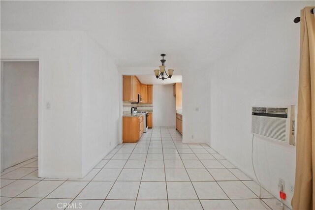 14127 Daubert St, San Fernando, CA 91340 - kitchen with a chandelier, light countertops, stainless steel range oven, light tile patterned flooring, and a wall mounted air conditioner