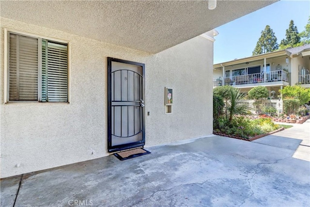 382 Avenida Castilla Unit B, Laguna Woods, CA 92637 - property entrance with stucco siding and a patio area